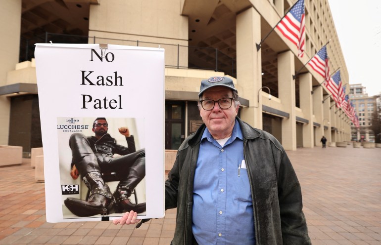 Un manifestante mantiene una señal que dice: "No Kash Patel."
