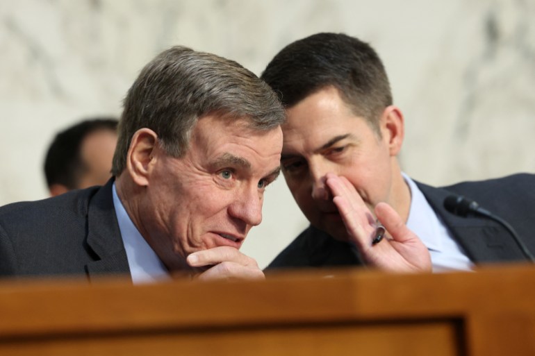 Tom Cotton susurra para Mark Warner en una reunión de inteligencia en el Senado.