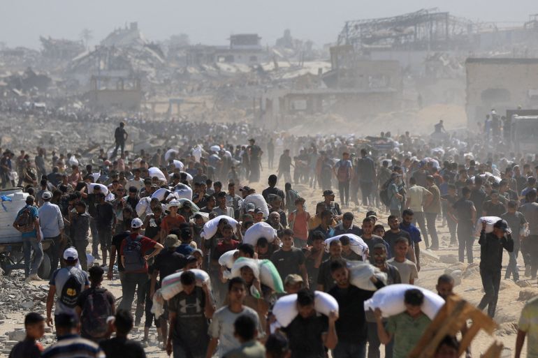 Los palestinos llevan suministros de ayuda que ingresaron a Gaza a través de Israel, en Beit Lahia, en la pista norte de Gaza, el 27 de julio de 2025. (Dawoud Abu Alkas/Reuters)