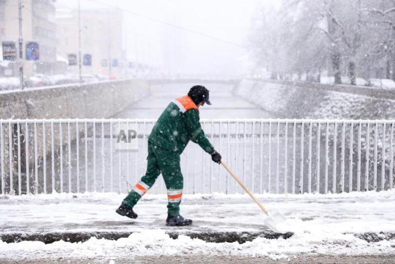 Un trabajador de servicios públicos limpia la nieve durante una fuerte nevada en el centro de Sarajevo, Bosnia, el lunes 23 de diciembre de 2024. (Foto AP/Armin Durgut)