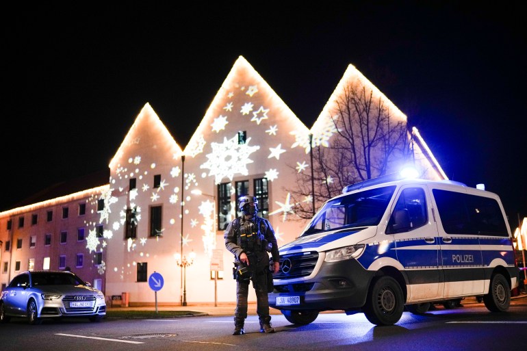 Un vehículo policial y un agente de policía cerca de un mercado navideño tras un presunto ataque en Magdeburgo