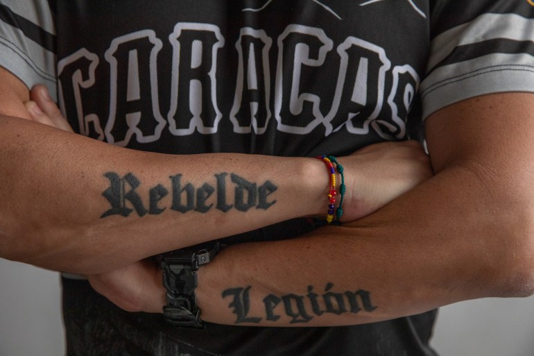Jesús Medina se cruza de brazos y dos tatuajes se extienden por la parte exterior de sus antebrazos: "Rebelde" y "Legión"